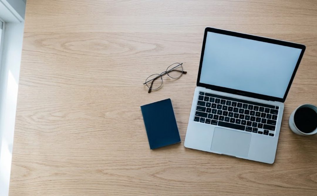 Útlevél, laptop, szemüveg és kávé egy íróasztalon – ESTA igénylés 2026